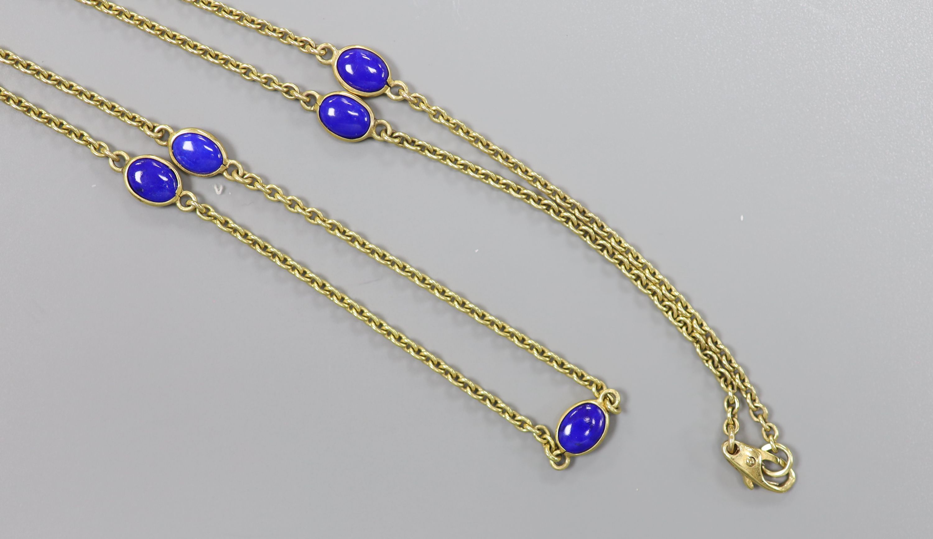 A modern 9ct gold and seven stone cabochon lapis lazuli set 'spectacle' necklace, 55cm